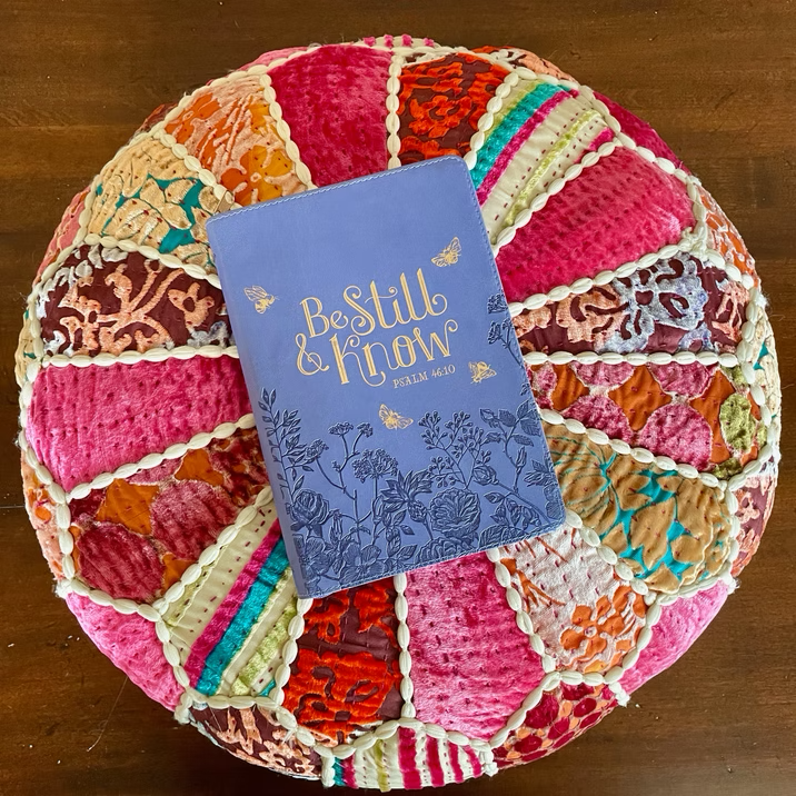 A Bible resting on a colorful meditation cushion