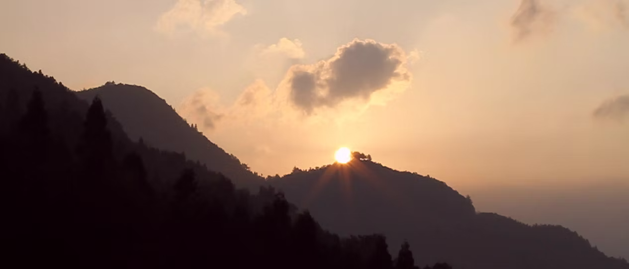 Sunrise appearing between peaceful mountain peaks